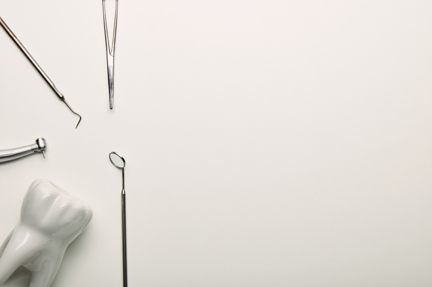 flache Lage mit rostfreien zahnärztlichen Instrumenten auf weißer Tischplatte, zahnmedizinisches Konzept - Foto, Bild