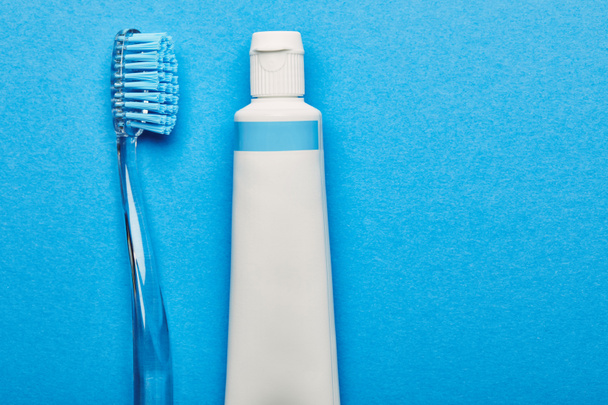 vista superior del cepillo de dientes y la pasta de dientes dispuestos sobre fondo azul, concepto de odontología
 - Foto, Imagen