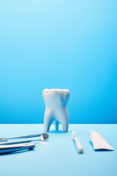 zár megjelöl kilátás fehér fogak modell, fogkefe, fogkrém és rozsdamentes Fogászati műszerek a kék háttér - Fotó, kép