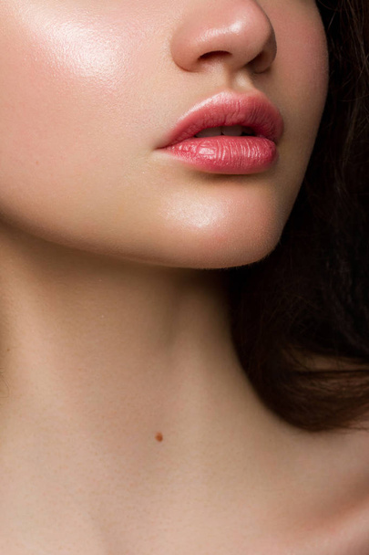Sexual full lips. Natural gloss of lips and woman's skin. The mouth is closed. Increase in lips, cosmetology. Pink lips and long neck. - Фото, изображение