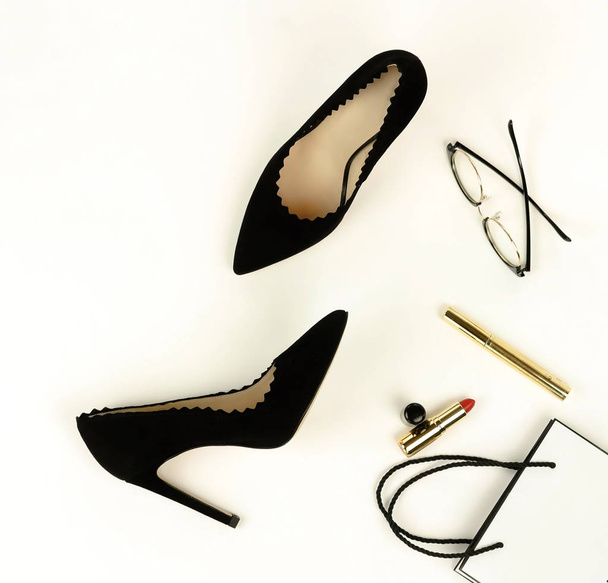 Flat lay, top view female black high heels shoes, accessories and make up cosmetics. bag, glasses, lipstick, mascara, on a white background.  Copy space. - Foto, immagini