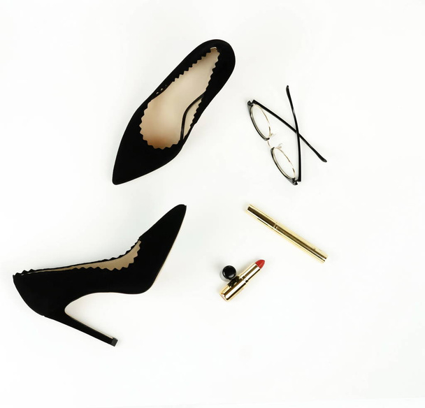 Flat lay, top view female black high heels shoes, accessories and make up cosmetics. bag, glasses, lipstick, mascara, on a white background.  Copy space. - Photo, image