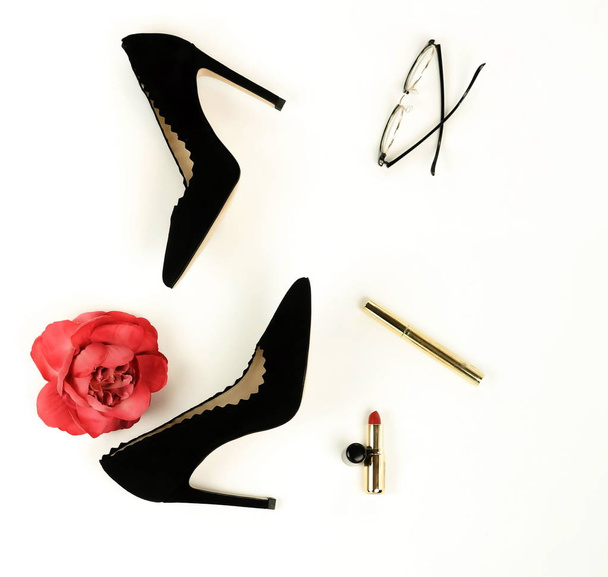 Flat lay, top view female black high heels shoes, accessories and make up cosmetics. bag, glasses, lipstick, mascara, on a white background.  Copy space. - Photo, Image
