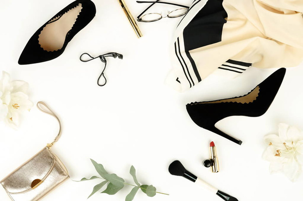 Flat lay, top view female black high heels shoes, accessories and make up cosmetics on a white background. bag, headscarf, glasses, lipstick, mascara, powder, brush, parfume .  Copy space. - Valokuva, kuva