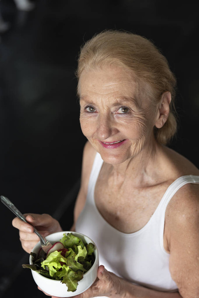 年配の女性は、健康的なサラダを食べるします。高齢者の健康ライフ スタイル コンセプト. - 写真・画像