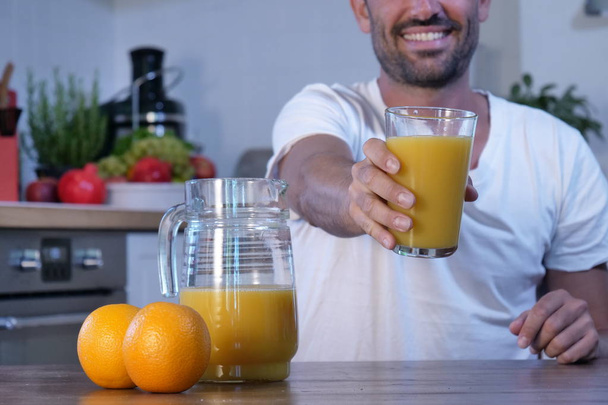 cropped image of man holding glass with squeezed fresh orange juice  - Foto, Imagem