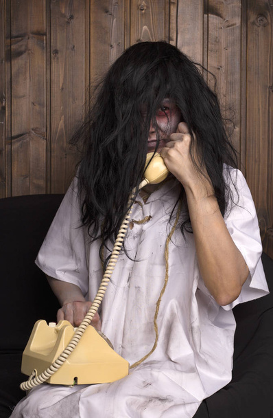 Концепция Хэллоуина. страшная девушка в белой ночнушке. Ведьма. с телефоном в руке
 - Фото, изображение