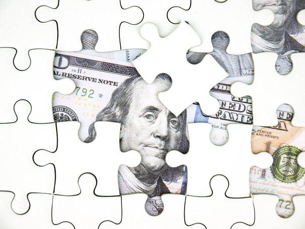 Missing jigsaw puzzle pieces on 100 Dollar money background, Key for Business solution success concept. - Photo, Image