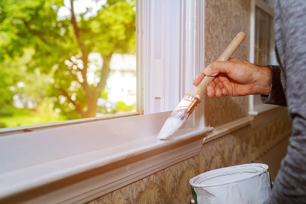 Macho manos reparaciones pintura ventana ajuste en casa primer plano
 - Foto, Imagen