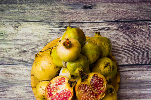 Fruta de granada en un plato de madera
 - Foto, imagen