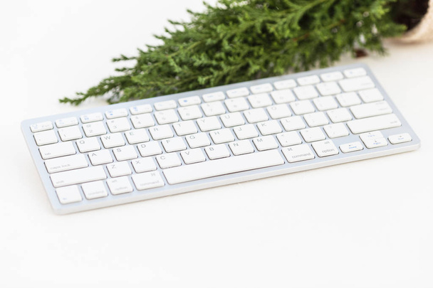 White keyboard and small christmas tree on white background. Template for blogging - Фото, зображення