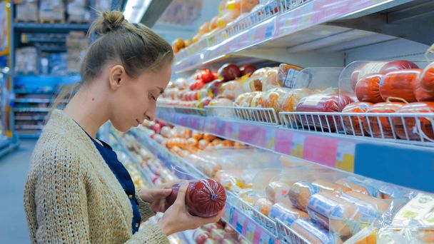 Mujer comprando salchicha en el supermercado
 - Foto, imagen