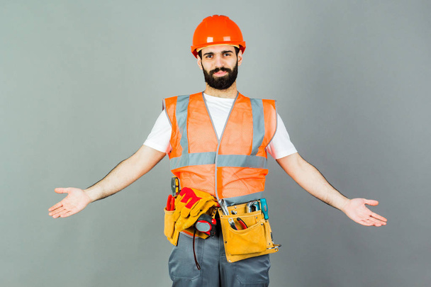 Man Builder with beard standing on gray background, copy space - Photo, Image