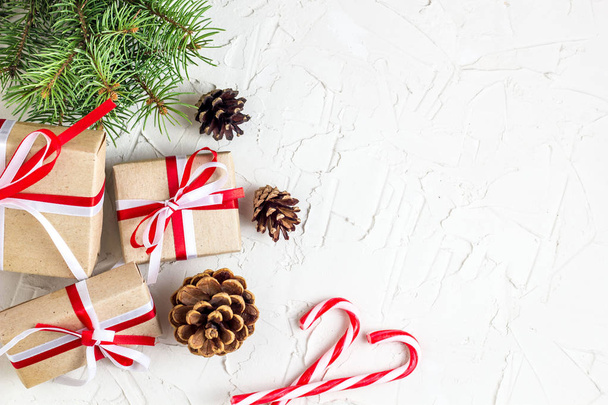 Χριστούγεννα ή Πρωτοχρονιά φόντο διακοσμήσεις με κουκουνάρια, κλαδιά έλατου, κουτιά δώρων και καλάμους καραμελών. - Φωτογραφία, εικόνα