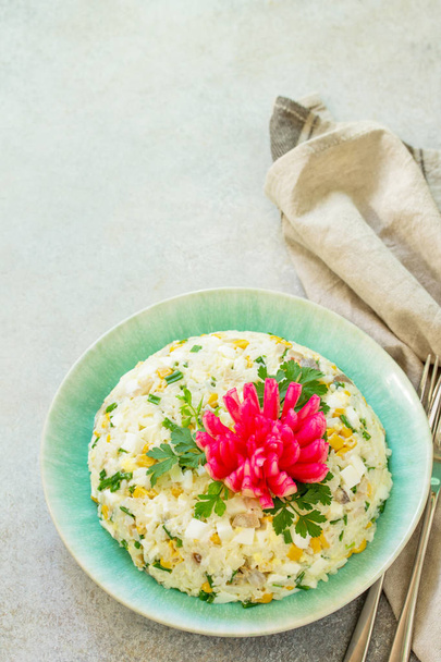 Festive Salad with Rice, Onion, Egg, Corn and Mushrooms on a gray stone or concrete table. Copy space. - Photo, Image