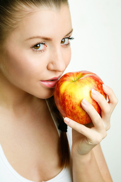 Beautiful young woman eating red apple - Photo, Image
