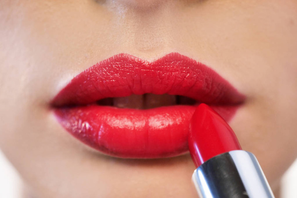 woman applying red glossy lipstick on lips  - Foto, Imagen