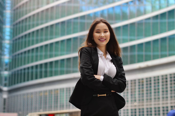 Portrait of a business woman, in a suit and tie, happy and smiling as she looks at the camera and crosses her arms, proud of her work. Concept of: success, finance and female career - Foto, Bild