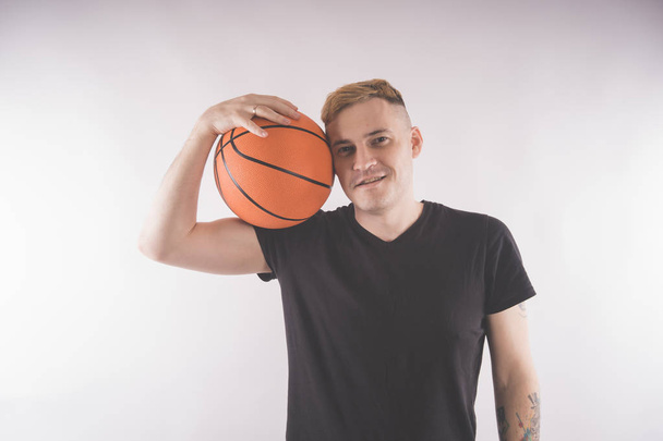 A guy with a basketball, a basketball player in training. The concept of sport and healthy lifestyle - Zdjęcie, obraz
