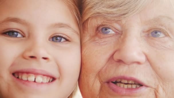 Close up portrait of grandmother and granddaughter. Bright violet eyes - Footage, Video