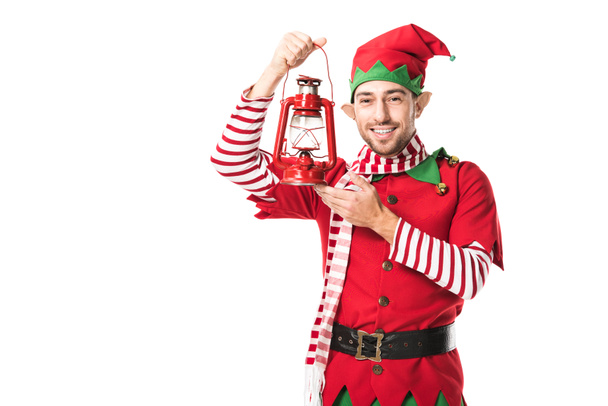 クリスマス エルフ衣装赤ランタンを押しながら白で隔離カメラ目線で陽気な男 - 写真・画像