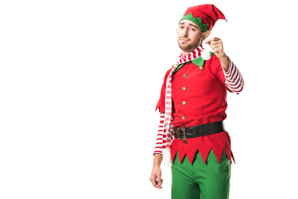 мужчина в рождественском костюме эльфа держит безделушку и смотрит на камеру на белом фоне
 - Фото, изображение