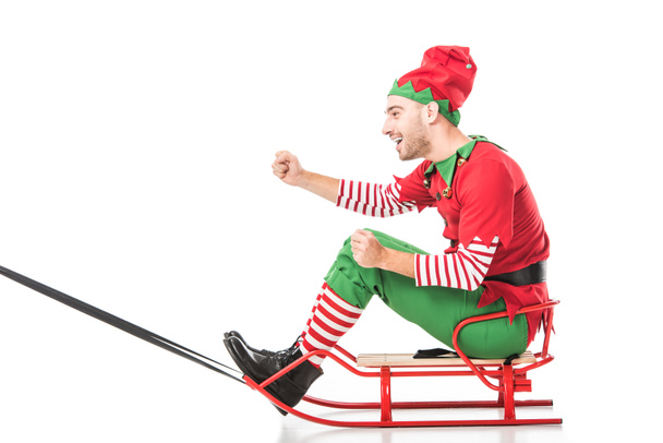 hombre feliz emocionado en traje de elfo de Navidad montar trineo aislado en blanco
 - Foto, imagen