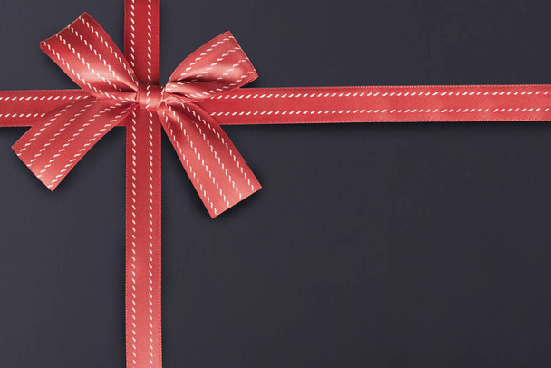 Red gift ribbon on a blackboard textured pattern in background. Gift box wrapping concept. - Фото, зображення