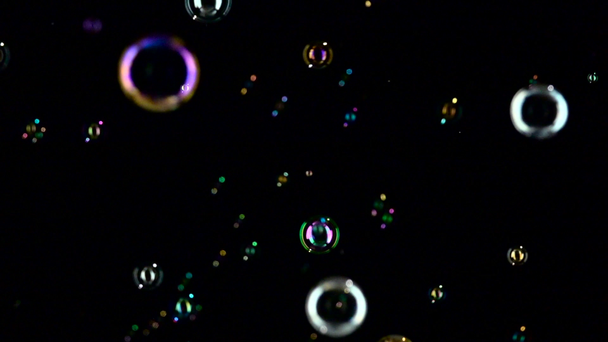 Las burbujas de jabón vuelan rápido. En cámara lenta. Fondos negros
 - Metraje, vídeo