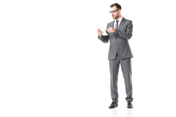 zakenman in pak en bril met behulp van digitale tablet geïsoleerd op wit  - Foto, afbeelding