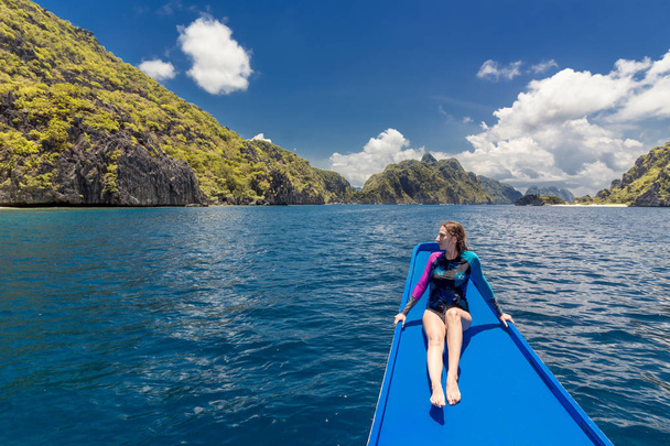 Mujer joven en el barco y mirando hacia adelante en la laguna. Recorrido por Asia: El Nido, Palawan, Filipinas
. - Foto, imagen