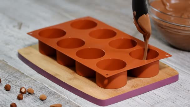 Mãos femininas enchendo um molde de silicone com uma mousse de chocolate. Fazendo sobremesa francesa
. - Filmagem, Vídeo