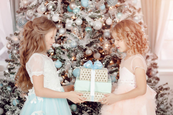 Onnellinen lapset tytöt sisaret vaihtaa uudenvuoden joululahjoja
 - Valokuva, kuva