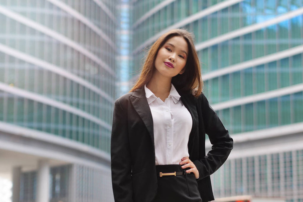 Portrait of a business woman, in a suit and tie, happy and smiling as she looks at the camera and crosses her arms, proud of her work. Concept of: success, finance and female career - 写真・画像