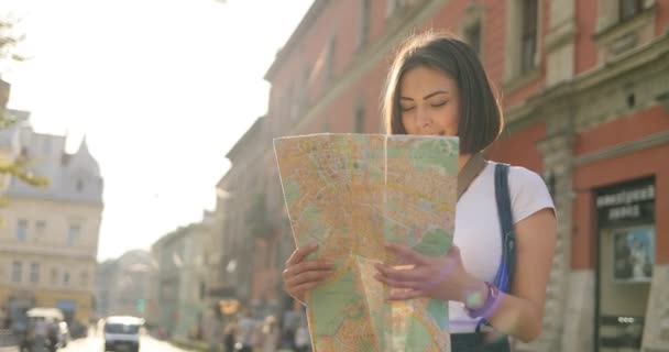 A girl is looking for a place on a map outdoors - Séquence, vidéo