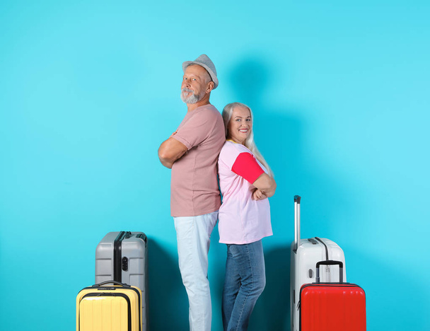 Senior couple with suitcases on color background. Vacation travel - Fotó, kép