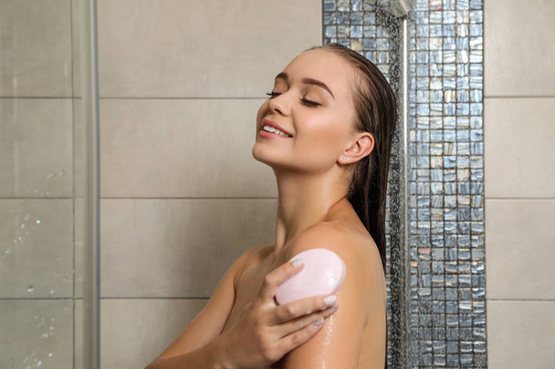 Beautiful young woman taking shower with soap in bathroom. Space for text - Fotoğraf, Görsel