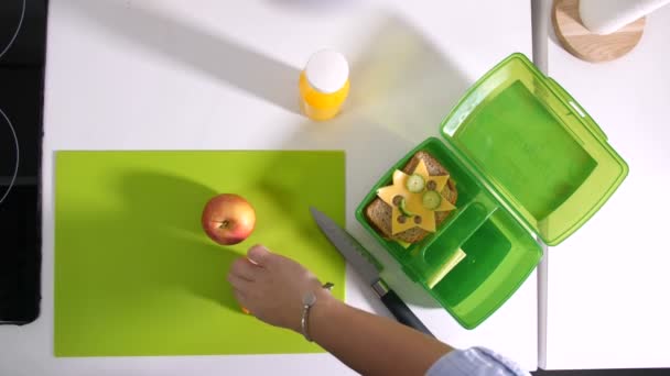 Жіночі руки упаковки їжі в шкільній обідній коробці
 - Кадри, відео