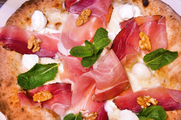 Zusammensetzung einer typisch italienischen Pizza mit typischen Zutaten der italienischen Gastronomie. Konzept von: Pizza, italienische Tradition, Neapel, mediterrane Aromen - Foto, Bild