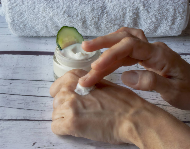 zelfgemaakte komkommer crème op een witte houten achtergrond, handgemaakte natuurlijke cosmetica - Foto, afbeelding
