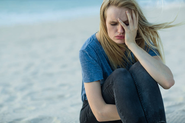Smutny depresji kobieta siedzi na plaży płacz.  - Zdjęcie, obraz