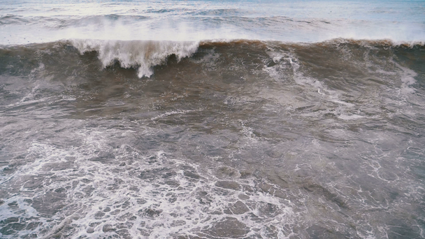 Tormenta en el mar. Grandes olas se están estrellando y rociando en la orilla. Moción lenta en 180 fps. Primer plano. Potente fuerza de la naturaleza golpeando las grandes olas de la playa. Una tormenta severa en la fuerza del huracán
 - Metraje, vídeo