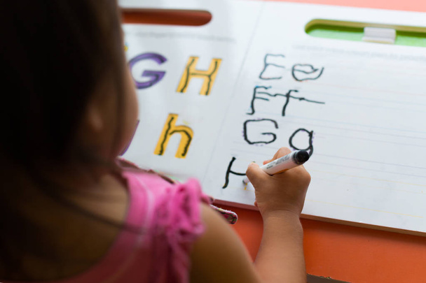 kids learning in classroom. homeschooling concept. close of tracing the alphabet - Photo, Image