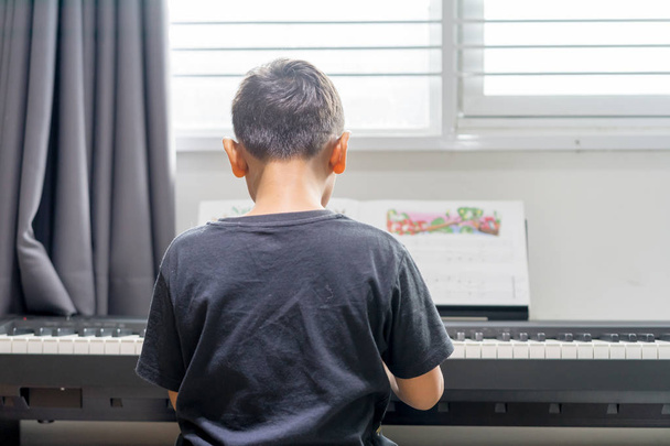 asiático garoto menino tocando o piano no quarto
 - Foto, Imagem