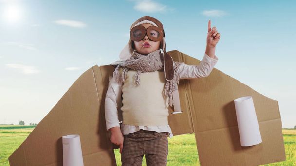 航空従事者またはパイロットとして服を着て寝室に少女は、自然バック グラウンドで紙飛行機を運転するふりをして彼女は空を飛んで自由を想像します。概念: 自由、成功、夢 - 写真・画像