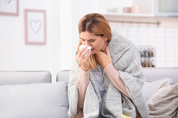 Woman suffering from cough and cold on sofa at home - Φωτογραφία, εικόνα