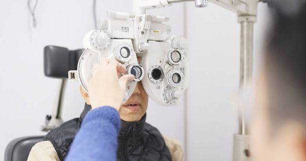 Ασιατικές ανώτερος άνθρωπος κάνει εξέταση των ματιών  - Φωτογραφία, εικόνα