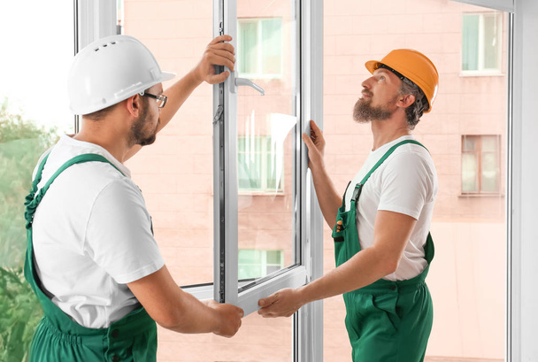 Construction workers installing new window in house - Фото, зображення