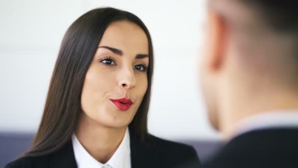 4k. Aantrekkelijke Glimlachende zakenvrouw, brunette, praat met de man in kantoor. Gezicht close-up - Video