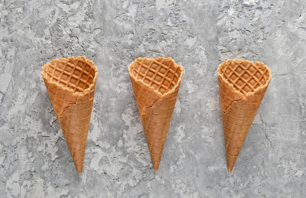 Three empty waffle horns on a concrete background. Top view, creative background, minimalist tren - Foto, immagini